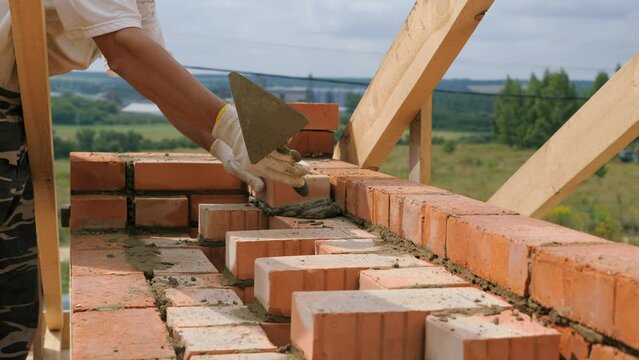 Laying out a brick chimney chimney of a private wooden house.