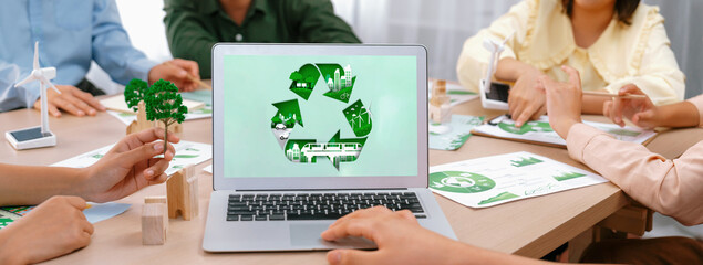 Recycle sign displayed on green business laptop while business team presenting green design to customer. ESG environment social governance and Eco conservative concept. Closeup. Delineation - obrazy, fototapety, plakaty