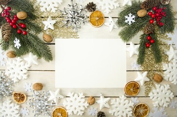 Christmas background for writing text for the holidays of Christmas and New Year.  On the table is a white sheet of paper with New Year's decorations and green spruce branches.  Space for copying text