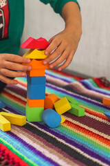 game colored geometric shapes children close-up on the table and the child plays selective focus