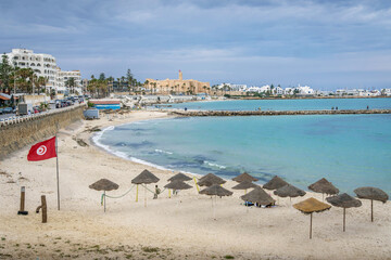 The beach and Mediterranean sea coastline at resort town of Monastir, Tunisia, with the long pier,...