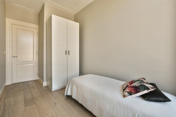 a bedroom with white walls and hardwood flooring the room is decorated in neutral tones, including...
