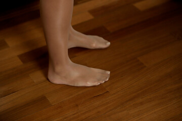 woman's feet with pantyhose on wood