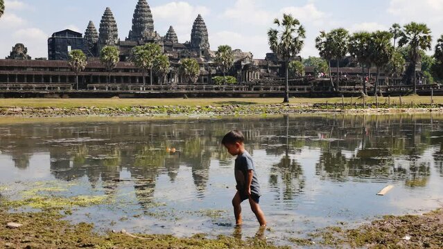 Child plays in front of the Angkor Wat temple in Cambodia