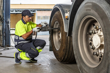 Male mechanic repairing car wheel