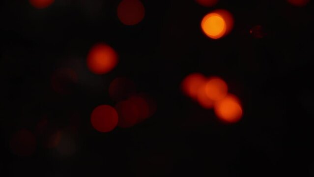 Red and green bokeh holiday lights flickering in the dark. Abstract Christmas background. Slow motion. 