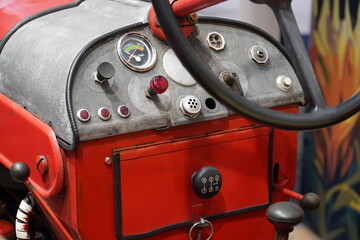 Cockpit with armatures, steering wheel and key lock of a vintage diesel tractor at an agricultural...