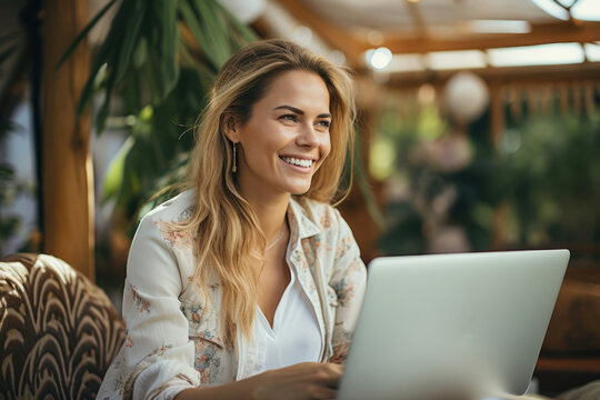 Charming young Caucasian woman in home clothes with laptop and morning cup of coffee in cozy room. Female specialist works online, participates in conference call. Remote job concept.