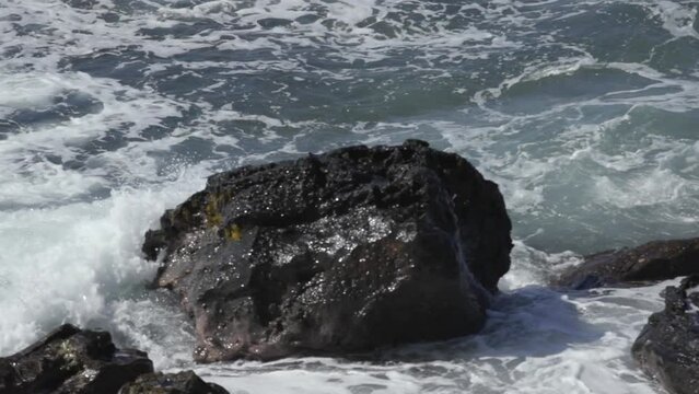 Slow motion wave crashing into rocks Maui Hawaii