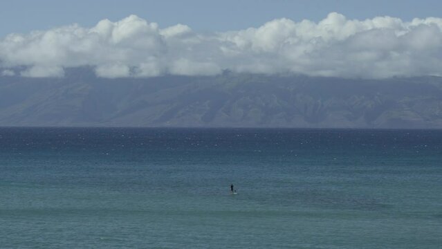 Stand up paddle surfer looking for waves Maui Molokai Hawaii