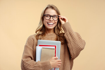 Confident smiling university student wearing stylish glasses holding laptop and books isolated on...
