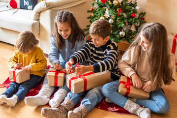 Cheerful Kids Discovering Christmas Presents at Home