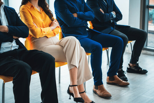 Diversity candidates siting while waiting for job interview with arm crossed in side view. Low section cropped image of business people smiling with confident. Modern waiting room. Intellectual.