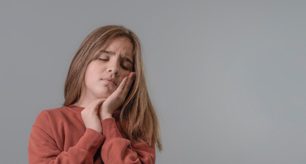 Teen girl with toothache. Touching mouth with hand with painful expression