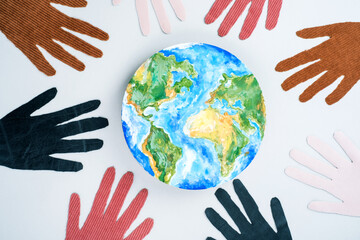 International Day for Tolerance with planet earth and the eight hands in a circle. Isolated on grey background. top view