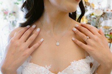 woman wearing large necklace and earrings holding on to a wedding dress
