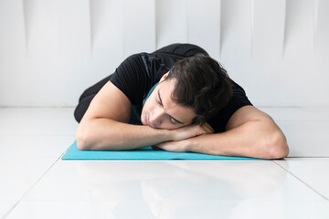 Tired young man sleeping while training on the floor at home. Do sport and exercise at the morning...