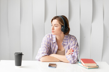Young attractive woman in headphones studying online at home. Distance education concept