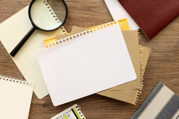 different pages on the table and a magnifying glass. Blank notepad page for entering text in the...