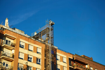scaffolding and mechanical lift for repair work on the roof of a building