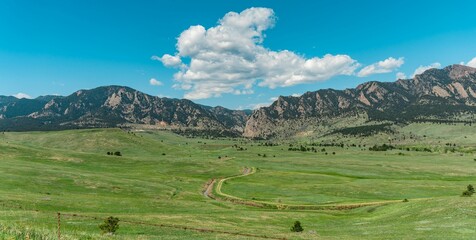 Fototapeta na wymiar Scenic view of a green field against a mountain range