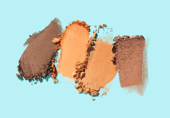 Eye shadow shimmering matte multi colored orange yellow nude brown palette texture background blue isolated 