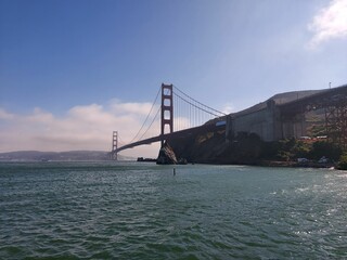 a bridge across the water with a large building in the background