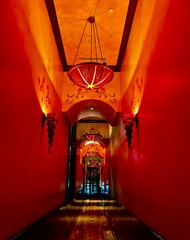 Contemporary hallway with vibrant red walls illuminated by hanging lamps of the same color