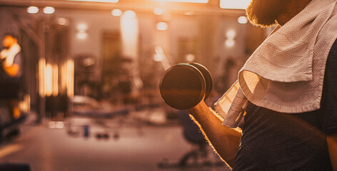Man training in a gym ,Fitness man with dumbbell in gym. looking away