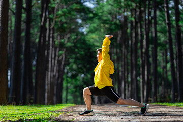 Trail runner is stretching for warm up outdoor in the pine forest dirt road for exercise and workout activities training for achieving healthy lifestyle and fitness