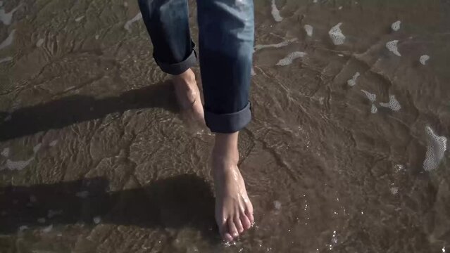 a girl walks barefoot on the sea