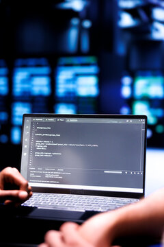 Admin team maintaining and updating server rigs, writing lines of code on laptop terminal, close up. Coders using JavaScript, Java, and database programming to ensure seamless data center computing