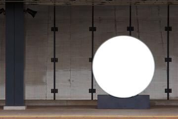 Round billboard on a railway platform, empty station. Mock-up.