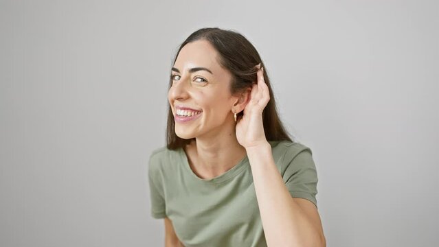 Vibrant young hispanic woman in casual clothes strikes a gossip-listening gesture. exudes charm despite her deafness. isolated white background capturing every glint of secret rumors.