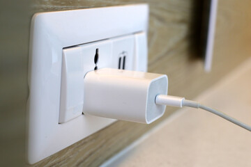 Hand insert a plug of the phone charger into socket.