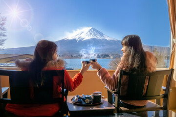 Japanese family relaxing in their room.Bedroom has a view of Mt Fuji.Fuji view outside the window. - obrazy, fototapety, plakaty