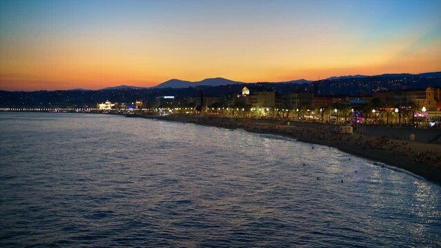 Panoramic view of Nice, France from a view point at sunset. Promenade des Anglais with illumination, classic buildings, Mediterranean sea coast