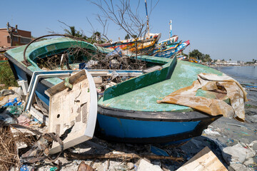 Fototapeta na wymiar un bateau abandonné à l'état d'épave sur une plage de la ville de Dakar au Sénégal en Afrique