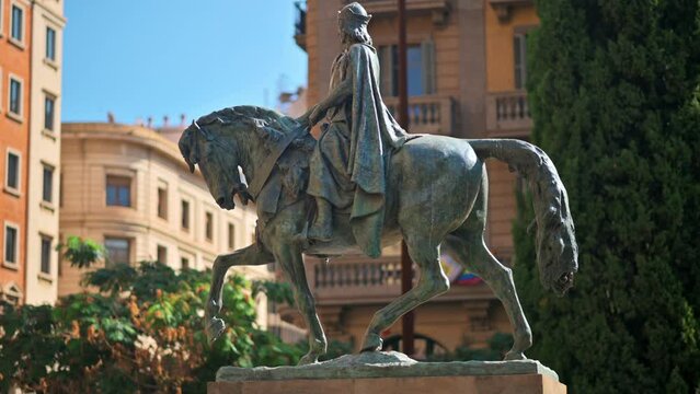 Close view of the Monument to Ramon Berenguer the Great in Barcelona, Spain. Greenery and old buildings on the background