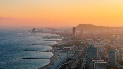 Aerial drone view of Barcelona at sunset, Spain. Mediterranean sea cost in city downtown with multiple buildings - Powered by Adobe