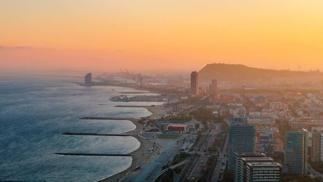 Aerial drone view of Barcelona at sunset, Spain. Mediterranean sea cost in city downtown with multiple buildings