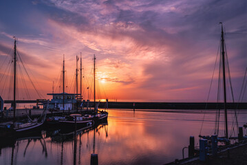 Sailboats in the port of Harlingen (Netherlands) at sunset