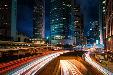 Fotobehang Street traffic in Hong Kong at night. Office skyscraper buildings and busy traffic on highway road with blurred cars light trails. Hong Kong, China © Dmitry Rukhlenko