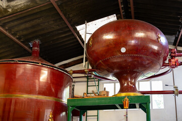 Double distillation process of cognac spirit in Charentias copper still pots and boilers in distillery in Cognac white wine region, Charente, Segonzac, Grand Champagne, France