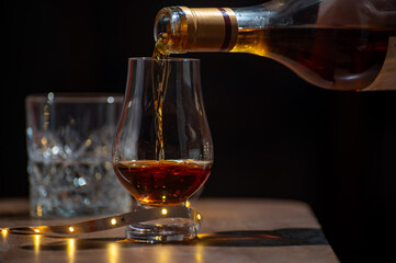 Glasses of single malt and blended scotch whisky served in bar in Edinburgh, Scotland, UK with party lights on background
