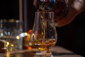 Glasses of single malt and blended scotch whisky served in bar in Edinburgh, Scotland, UK with party lights on background