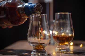 Glasses of single malt and blended scotch whisky served in bar in Edinburgh, Scotland, UK with party lights on background