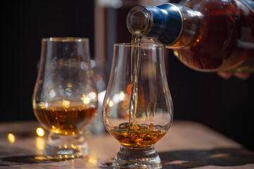Glasses of single malt and blended scotch whisky served in bar in Edinburgh, Scotland, UK with party lights on background - obrazy, fototapety, plakaty