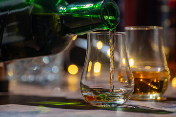 Pouring in Speyside whisky glass of whisky, single malt and blended scotch whisky served in bar in...