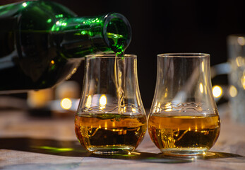 Pouring in Speyside whisky glasses of whisky, single malt and blended scotch whisky served in bar...